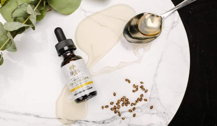 CBD-Öltropfen mit Samen und Eukalyptusblättern auf Marmor. Perfekt für Gesundheits- und Wellnessthemen.