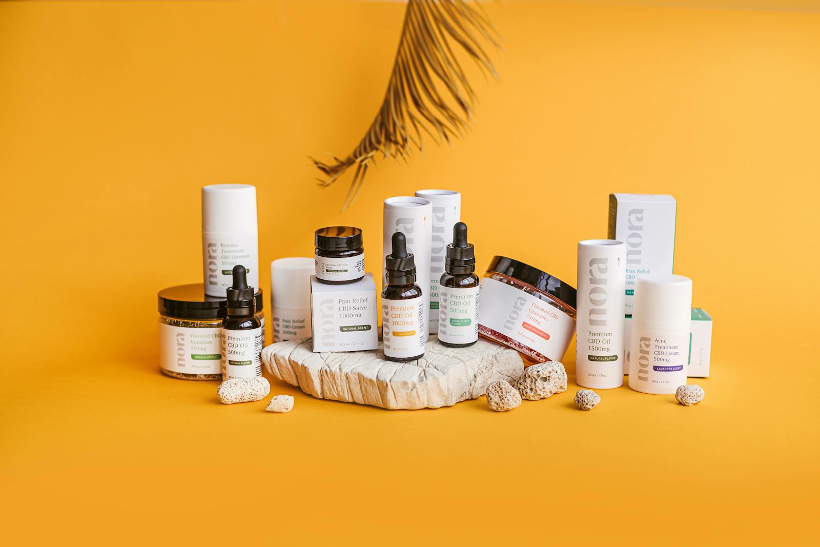 A collection of CBD cosmetic products on a bright yellow background, showcasing a modern and clean design.